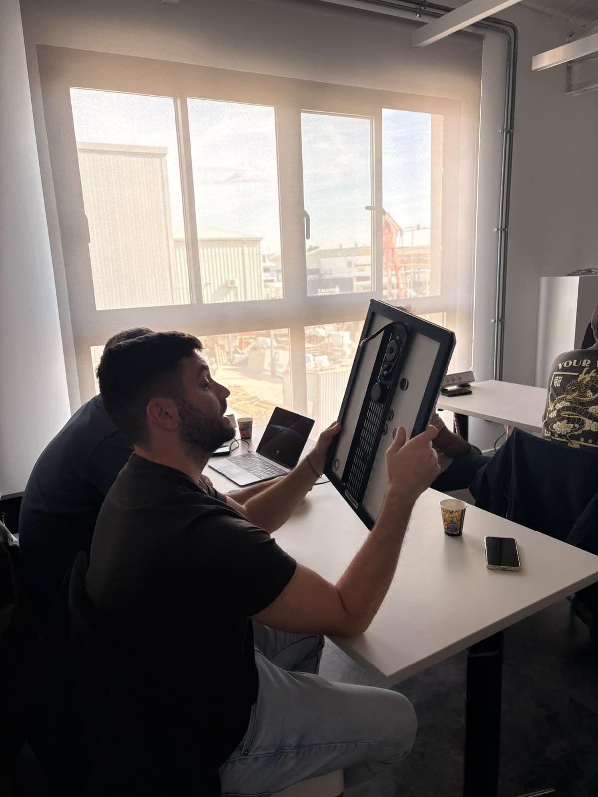An attendee examines the back of an installation speaker during the training